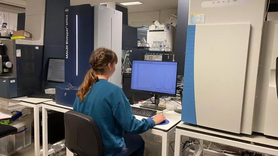 A research assistant using a MALDI Biotyper Sirius instrument